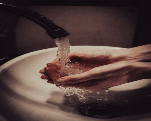 Washing hands under a modern faucet